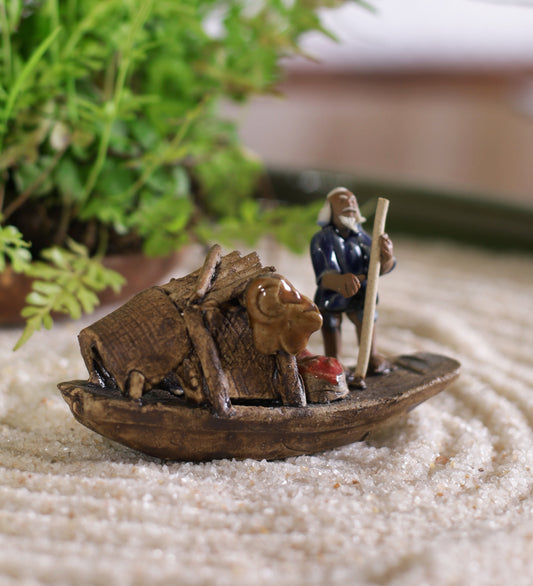 Old Fisherman In Blue Standing On Boat With Stick