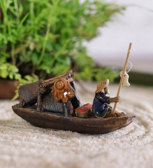 Old Fisherman In Blue Sitting On Boat With Fishing Rod