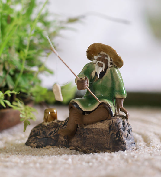 Old Fisherman In Brown With Fishing Rod On Rock