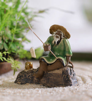 Old fisherman in brown with fishing rod on rock