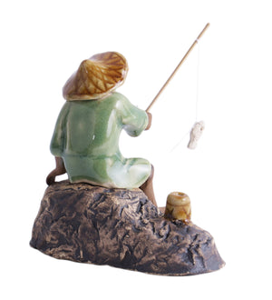 Old fisherman in brown with fishing rod on rock
